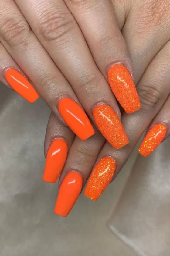 Uñas naranjas pastel color de los melocotones, y las hojas de otoñ