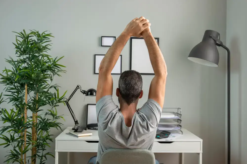A Man Stretching While Working From Home
