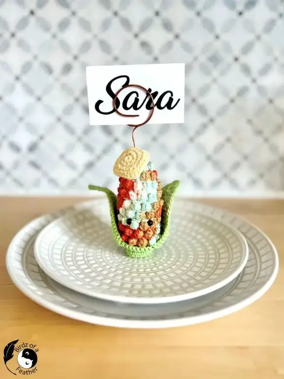 Crochet corn place card holder on a plate in an Indian corn style crocheted with ombre yarn