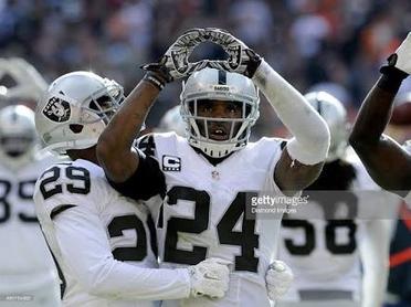 Oakland Raiders Charles Woodson (24) goes high to intercept a