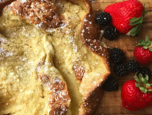 Dutch Baby with Fresh Berries Dutch baby pancake with powdered sugar and fruit.