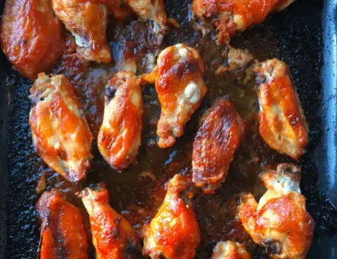 Close-up of baked chicken wings in a pan.