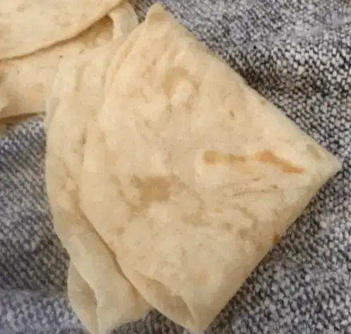 Homemade Tortillas! Folded flatbread on a gray fabric.