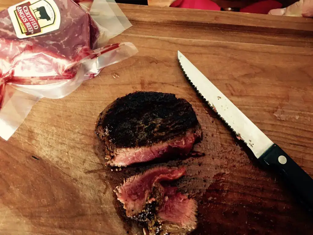 Seared steak on a wooden cutting board.