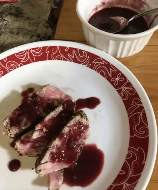 Seared Ahi Tuna with Blackberry Jalapeno Sauce Grilled meat with red wine sauce on a plate.