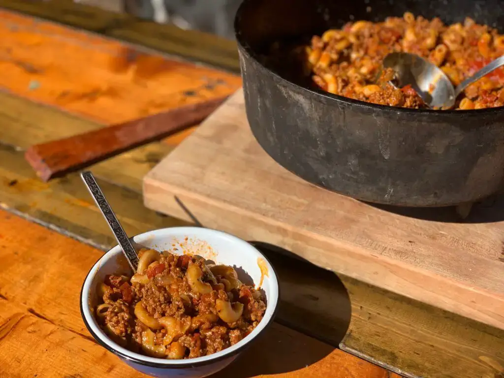 A bowl of goulash with a spoon.