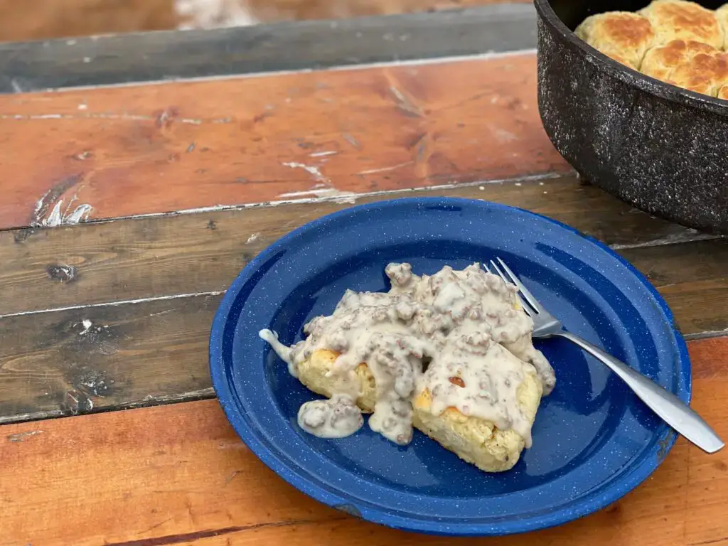 Biscuits and gravy on blue plate.