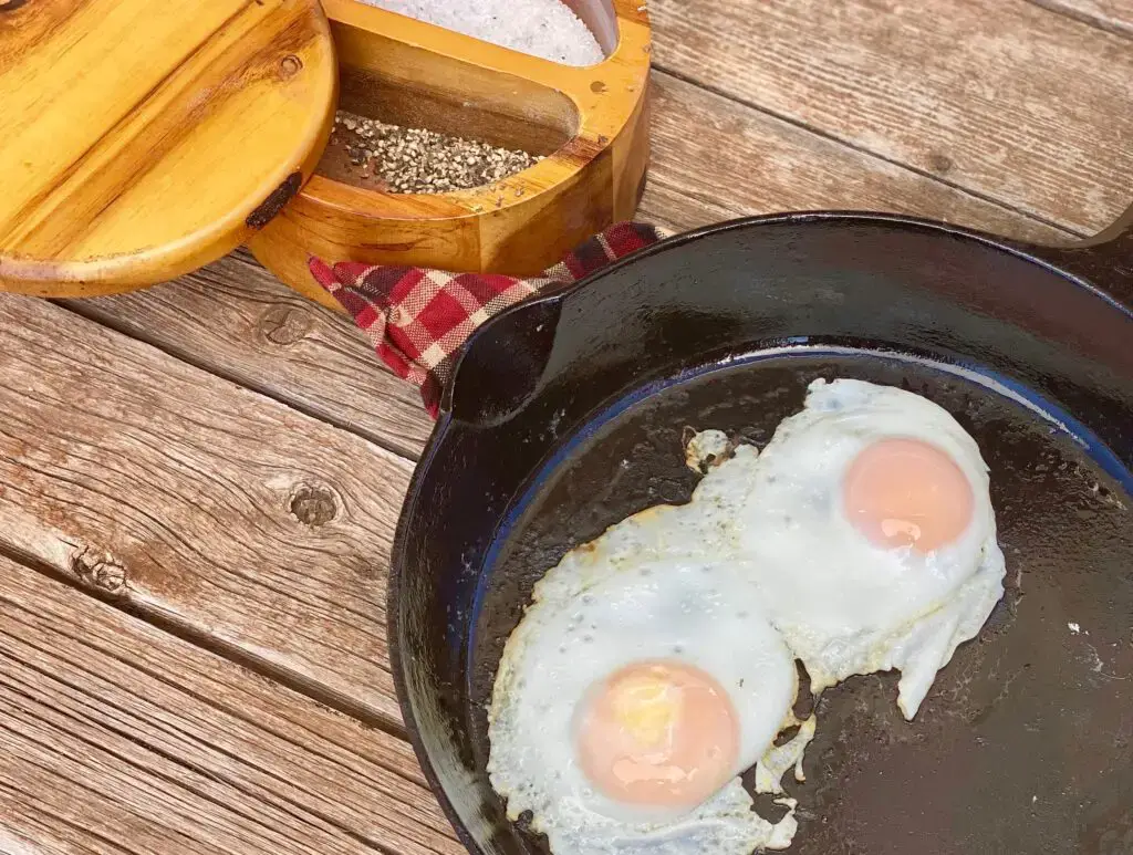 Two sunny side up eggs in a cast iron pan.