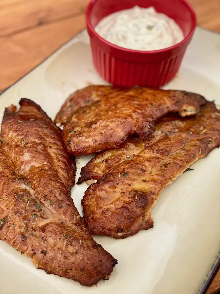 A plate of meat and sauce on the table.