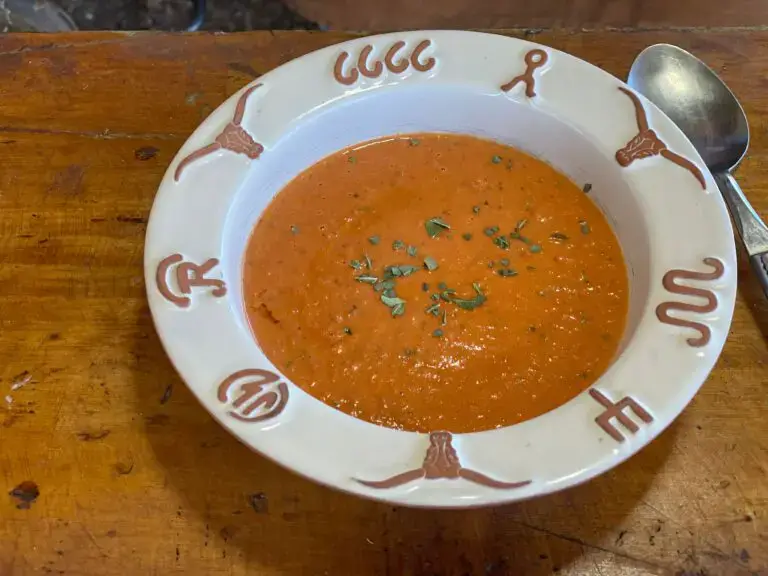 A bowl of soup on top of a wooden table.