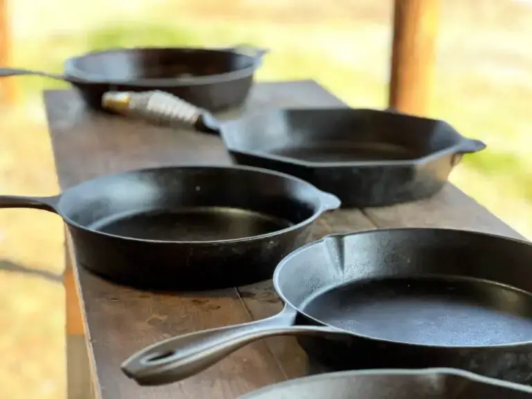 A table with several cast iron pans on it.