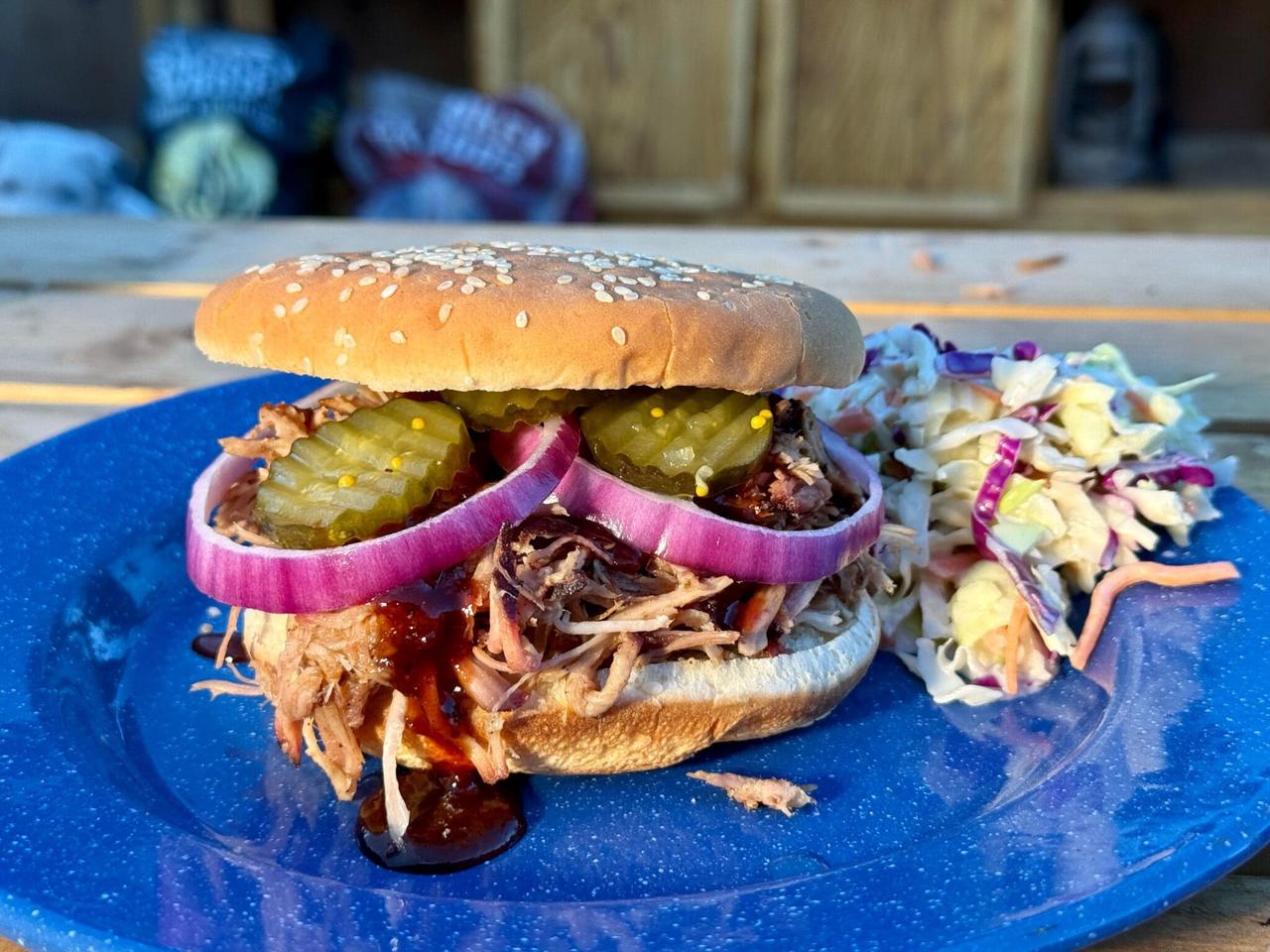 Kent Rollins Pulled Pork Sandwich on a blue plate with cole slaw