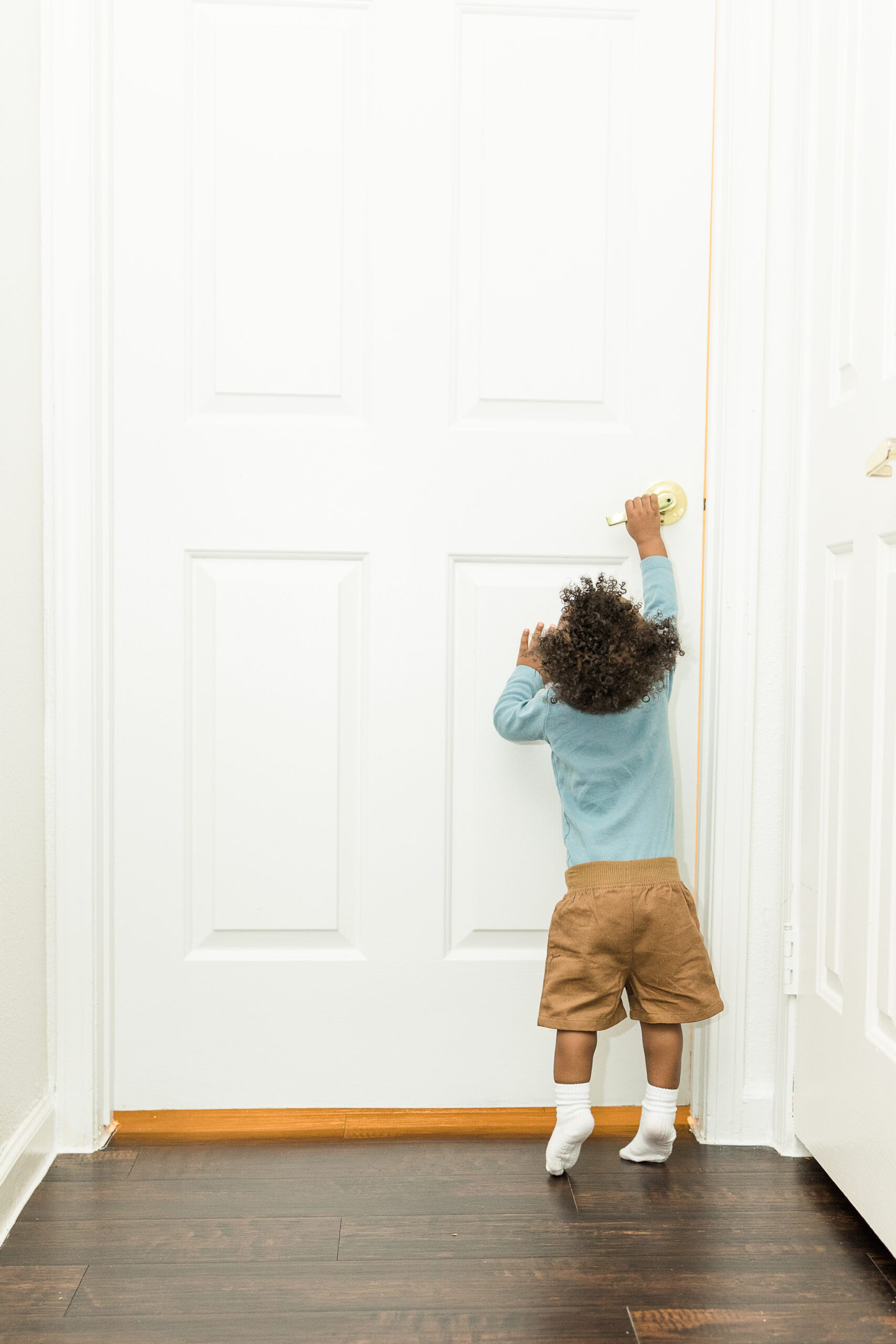 child reaching for door handle